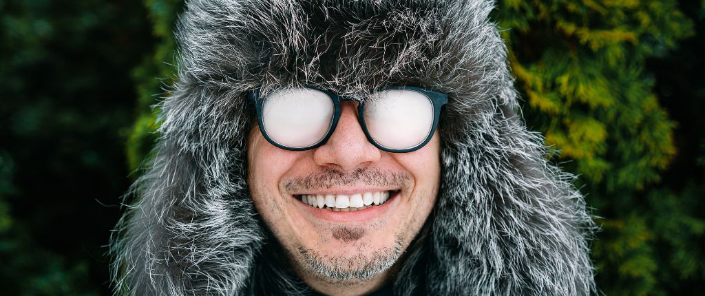 A person wearing foggy glasses in winter